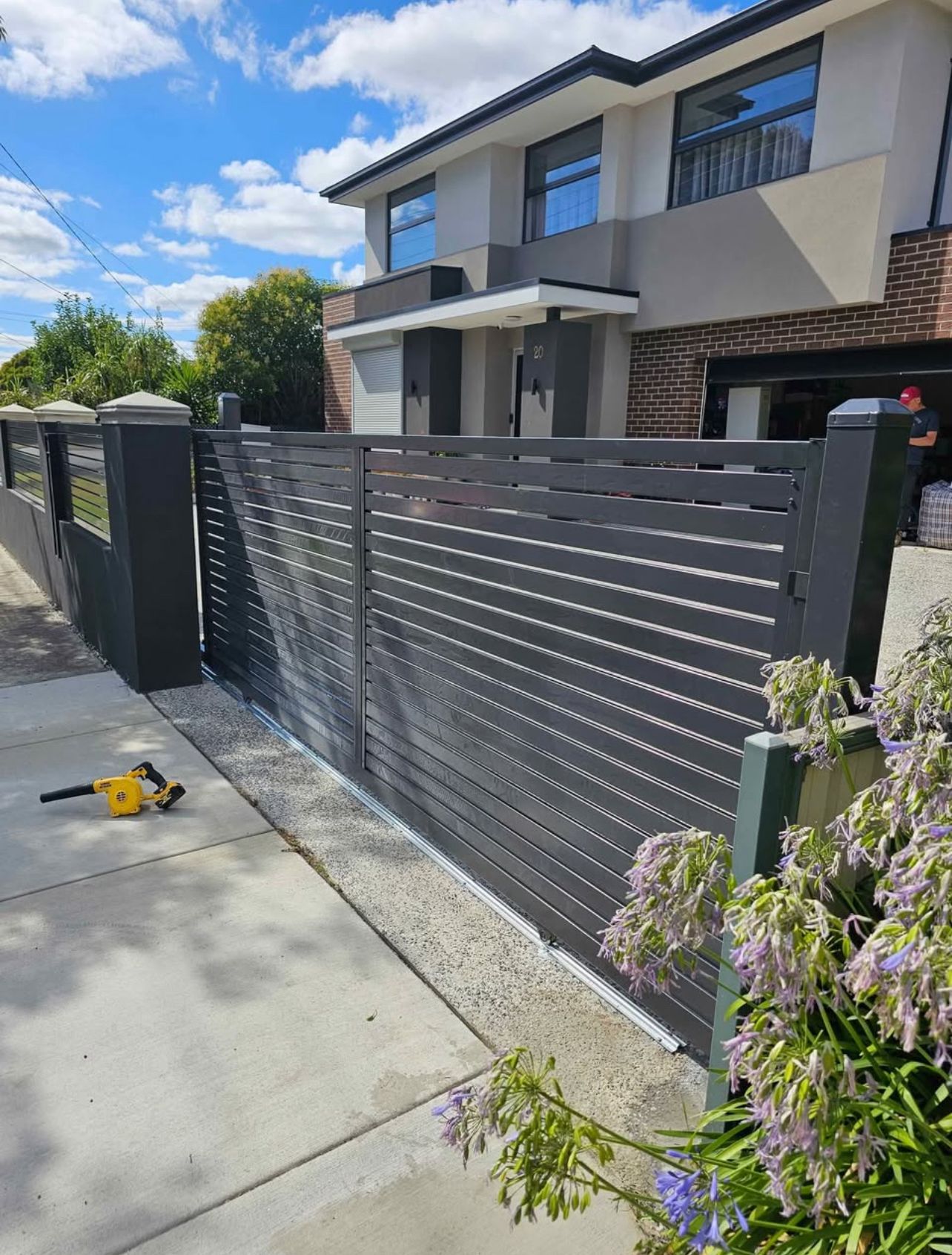 Grey aluminium slat sliding gate in front of a two-storey home, Roxburgh Park